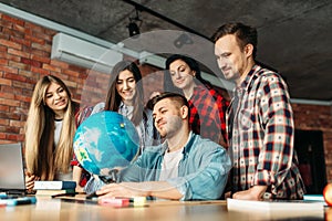 Group of highschool students looking at the globe