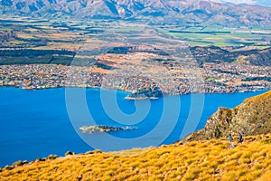 A group of hiker hiking on the beautiful track with a landscape of the mountains and Lake Wanaka. Roys Peak Track, South Island,