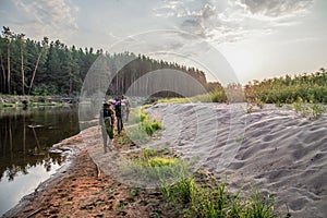 A group of hikers with backpacks travel near the river in Chernobyl zone