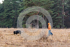 Group of hikers with dog pet bright colored jackets journey through autumn valley on forest background