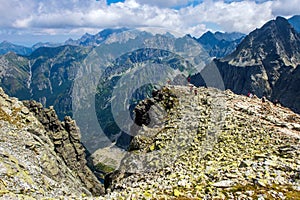 Group of hikers standing on a cliff against the backdrop of the High Tatra Mountains. Slovakia.