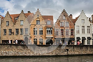 A group of historic brick gabled buildings by the canal in central Bruges.