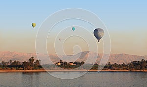 A group of hot air balloons soar in the air near Luxor.