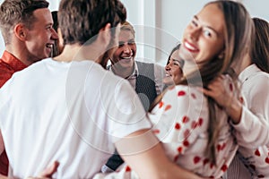 Group of hugging people having fun together.