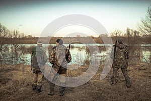 Group of hunters hunting in rural field at river during hunting season