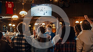 Group of Ice Hockey Fans Watching a Live Match Broadcast in a Sports Pub on TV. People Cheering