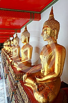 Group Images of Golden Buddha statue stucco in different posture in long corridor of Wat Phra Temple, Bangkok, Thailand