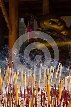 Group incense with candle and statue background