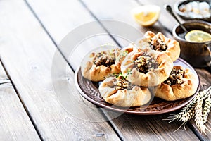 Group of individual pies with meat and potato - vak balish. Tatar traditional pies. Wooden background. Copy space