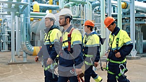 Group of industrial man builder walking at chemical production plant with oil gas petrol pipe