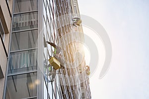 Group Industrial mountaineering workers in uniform washing exterior building glazing