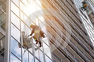 Group Industrial mountaineering workers in uniform washing exterior building glazing