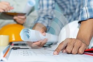 Group interior designer and architect planning and working on blueprint with safety helmet in meeting room