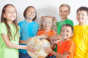 Group of international kids holding globe earth