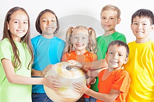 Group of international kids holding globe earth