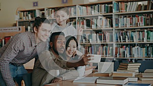 Group of international students have fun smiling and making selfie photos on smartphone camera at university library