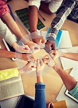 Group of international students making fist bump