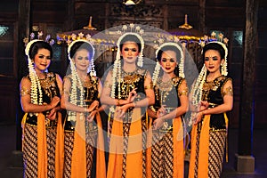 a group of Javanese dancers standing with their friends while wearing yellow costumes and shawls