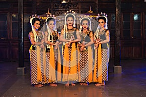 a group of Javanese dancers standing with their friends while wearing yellow costumes and shawls