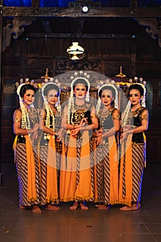 a group of Javanese dancers standing with their friends while wearing yellow costumes and shawls