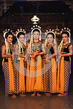 a group of Javanese dancers standing with their friends while wearing yellow costumes and shawls