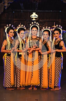 a group of Javanese dancers standing with their friends while wearing yellow costumes and shawls