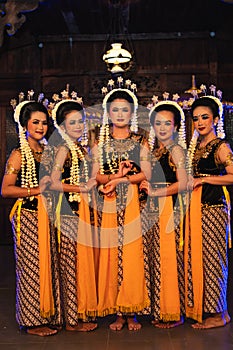 a group of Javanese dancers standing with their friends while wearing yellow costumes and shawls