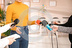 Group of journalists interviewing woman in room