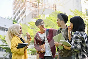 A group of joyful Asian-diverse college students are enjoying talking in the campus park