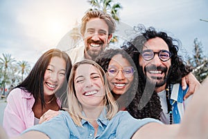 Group of joyful best friends having fun and laughing taking a selfie portrait together. Friendly young adult people