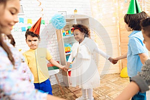 Group of joyful children dancing round dance on birthday party. Concept of children`s holiday.
