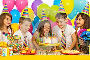 Group of joyful little kids with cake at birthday