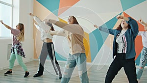 Group of joyful teenagers dancing in contemporary studio having fun with creative performance