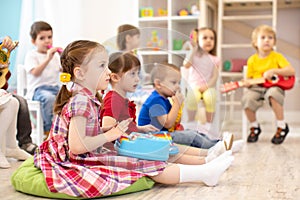 Group of kids 3-4 years old playing toy musical instruments. Early music education in kindergarten