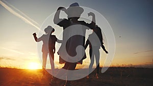 Group of kids dancing in the park silhouette at sunset. kid dream party fun concept. children dancing in nature at