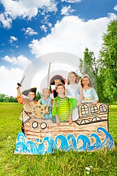 Group of kids in different costumes stand on ship