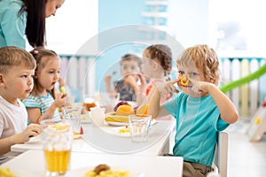 Group of kids have lunch in daycare