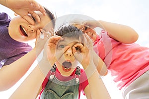 Group of kids having fun and making faces outdoors