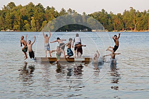 Group of kids jumping into Lake photo