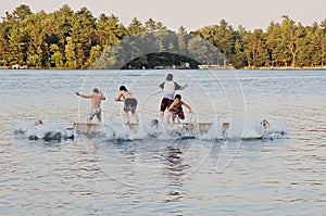 Group of kids jumping into Lake