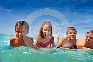 Group of kids lay in sea water swim and splah