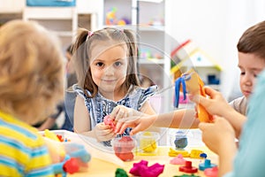 Group of kids play with modeling clay