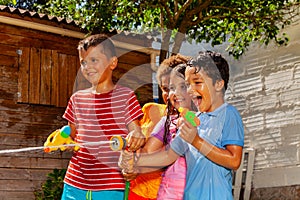 Group of kids play with water gun and sprinklers