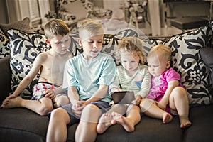 Group of kids playing with an electronic tablet devices