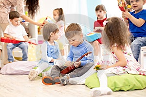 Group of kids playing musical toys. Early musical education in kindergarten