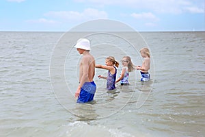 Group of Kids Playing in the Water in the Ocean on Summer Day