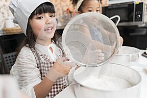Group of kids are preparing the bakery in the kitchen .Children learning to cooking cookies.