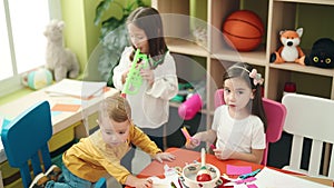 Group of kids preschool students sitting on table playing trumpet and making handcrafts at kindergarten