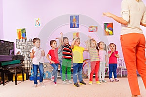 Group of kids repeating exercise after teacher