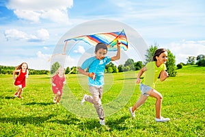 Group of kids run with kite